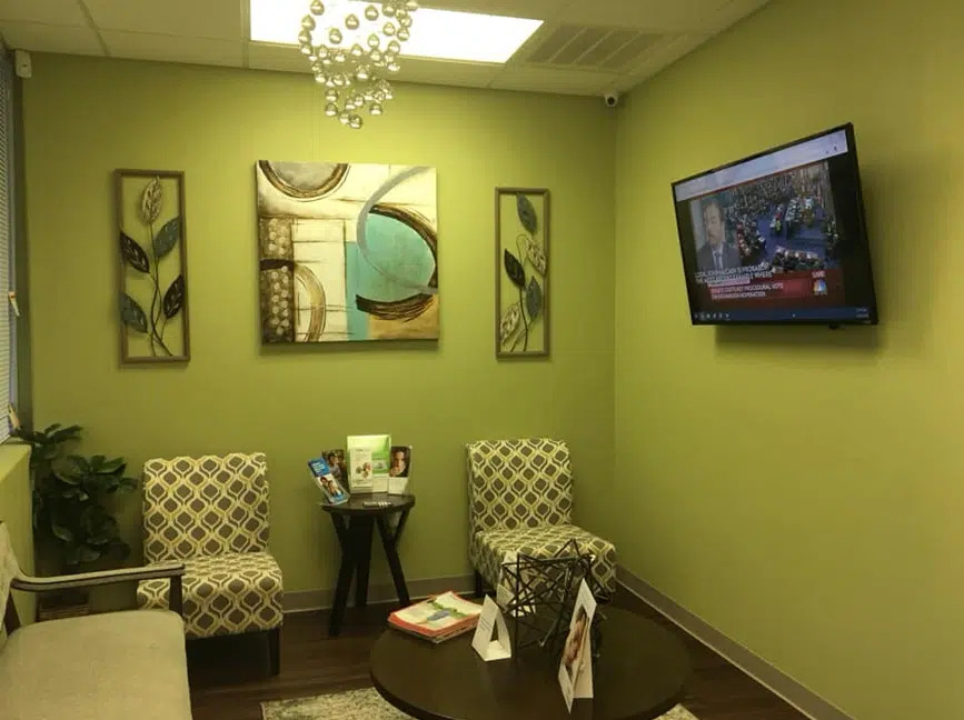 Waiting room with armchairs and a TV at Gentle Touch Dentistry, a dentist office in Richardson, TX
