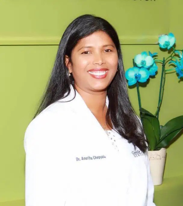 Dr. Anuritha Chepyala, dentist in Richardson, TX, smiling in a white coat at Gentle Touch Dentistry