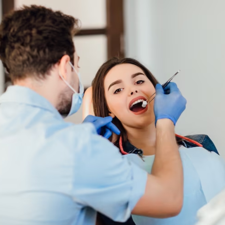 Dentist examining a patient's teeth in the dental chair — restorative dentist in Richardson, TX